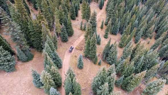 Aerial of Jeep Wrangler Off Roading Through Forest 4k